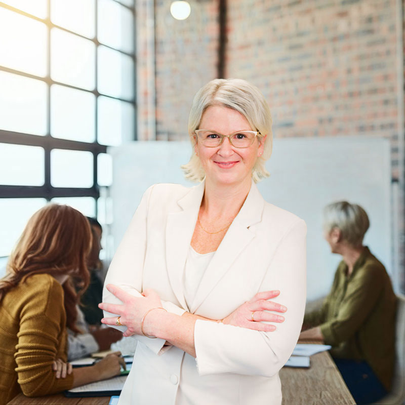 Fern-Sabo-owner of Spring-Creative-Inc-stands in an office of corporate professionals in Nelson-BC